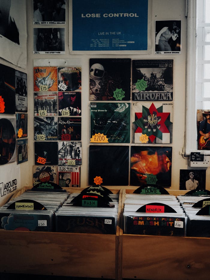 Retro vinyl records and albums lining the wooden shelves of a classic record store in Abergele, UK.